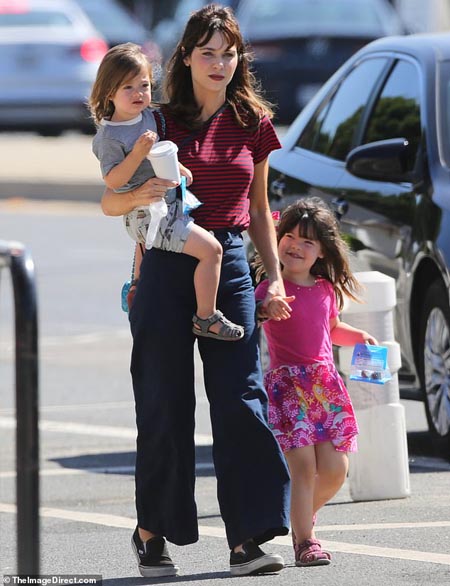 Zooey Deschanel and her kids in a parking space.